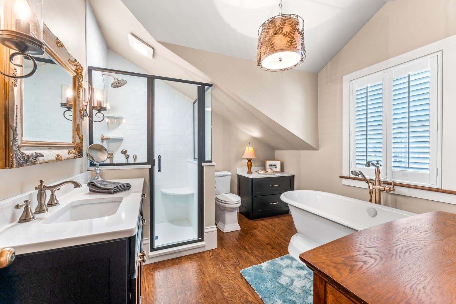 Pristine bathroom with walk in shower, sink with vanity, toilet, and soaking tub.