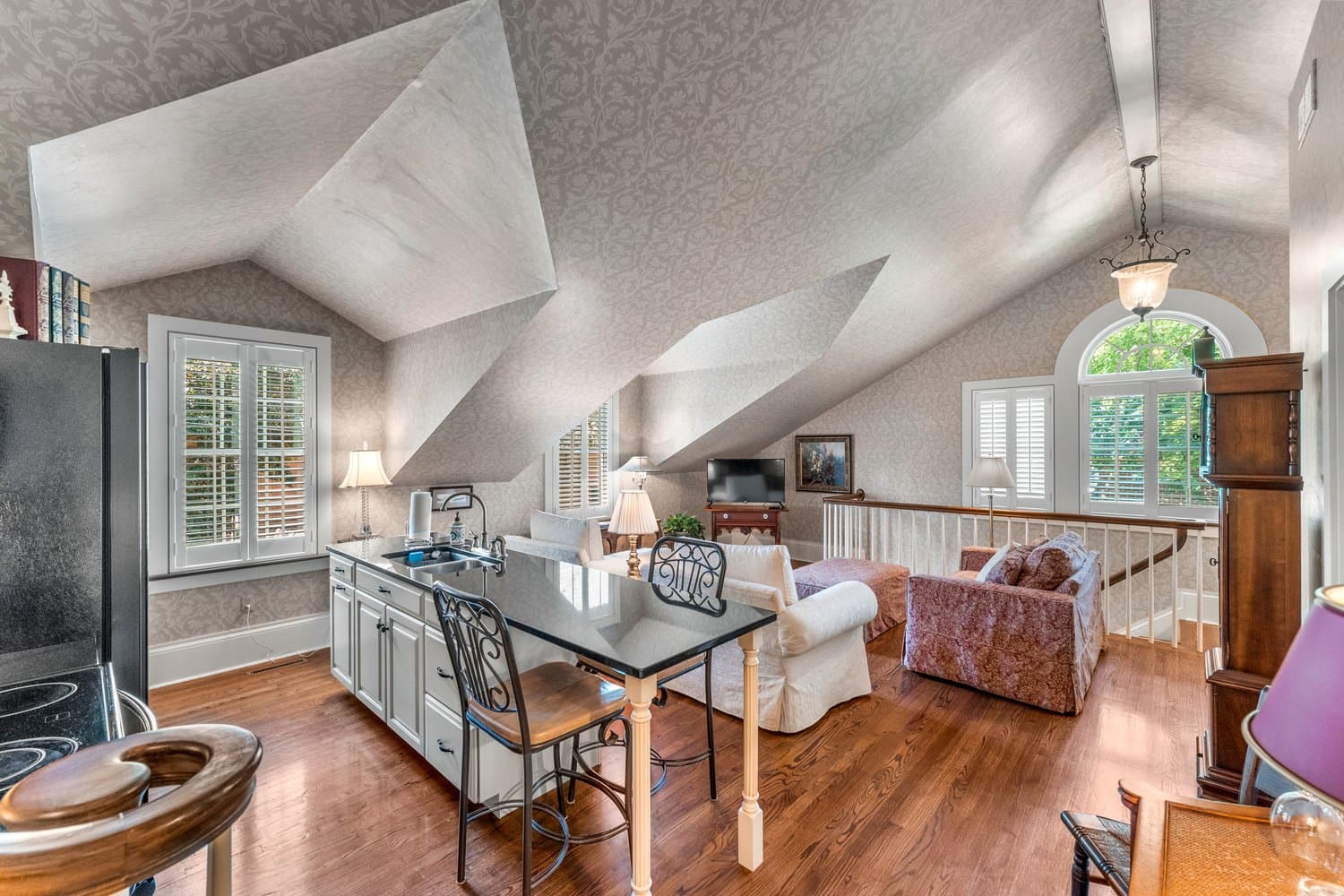 Cozy loft-style living area with vaulted ceilings, hardwood floors, and comfortable seating.